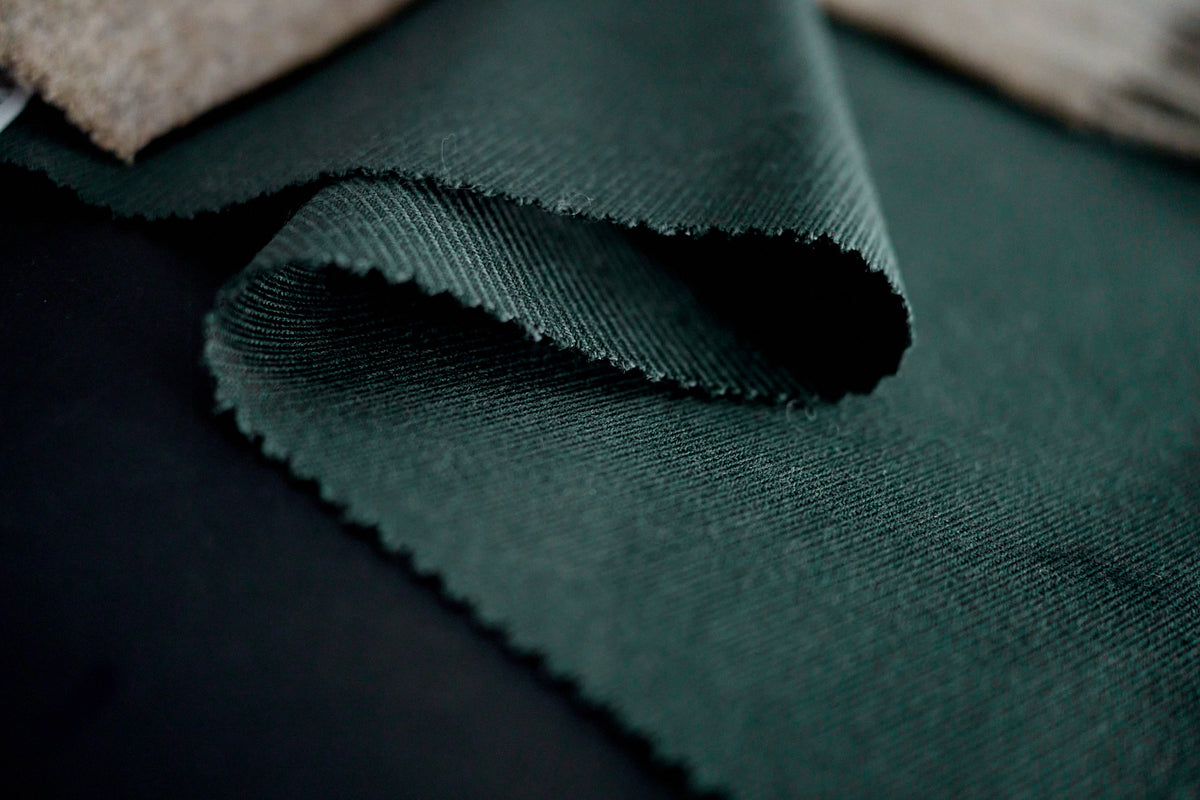 Fine tailored interior jacket seam showing a smooth Cupro lining and clean hand-finished stitching. Completely polyester-free inner construction.