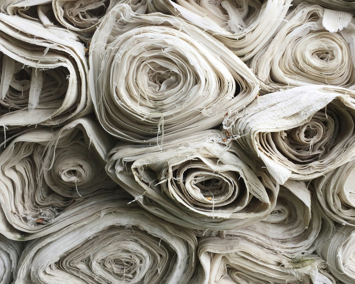 Textural macro flat lay showcasing RWS-certified organic wool, soft cashmere, and natural ramie fibers. Sustainable luxury fashion components.